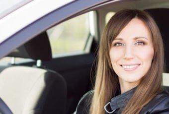 Young woman behind the wheel of her car